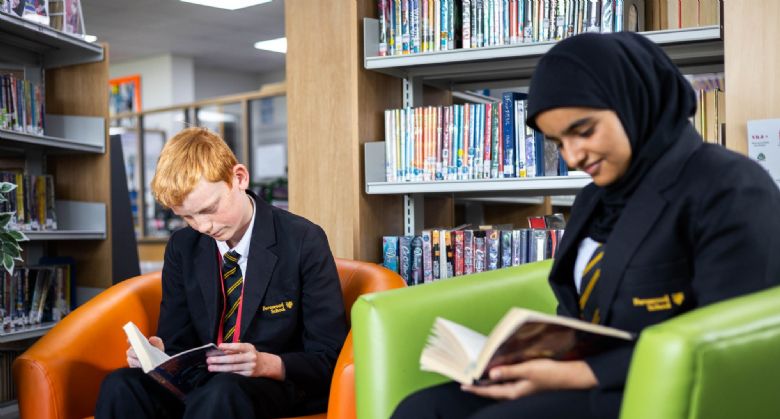 Image of student reading books in the school library