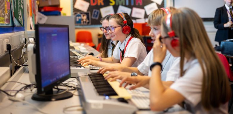Image of students using music keyboards with Apple Macs