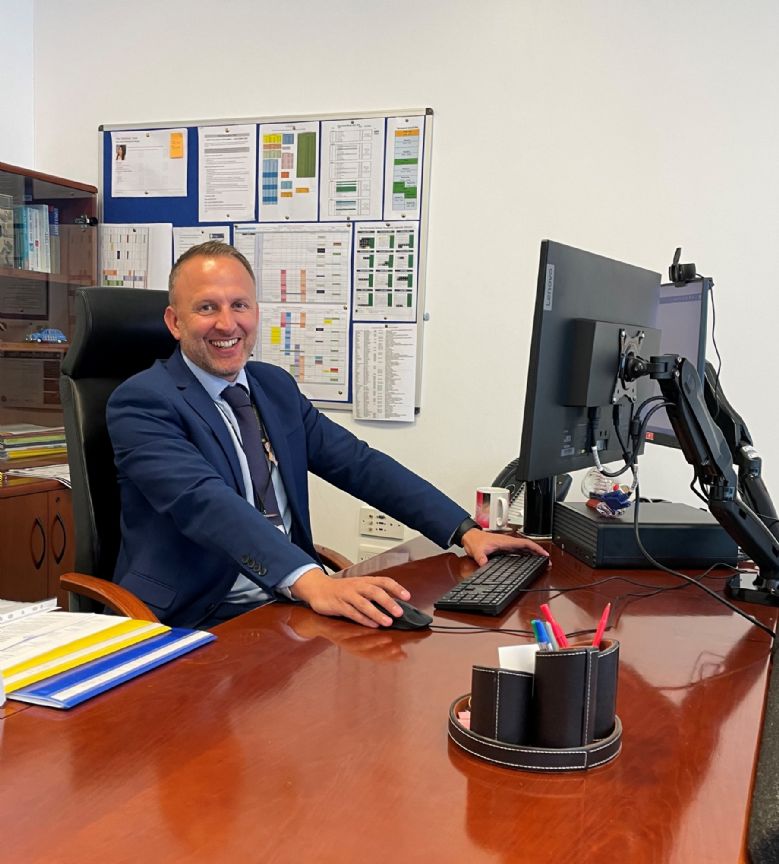 Image of the Head Teacher sat at his desk